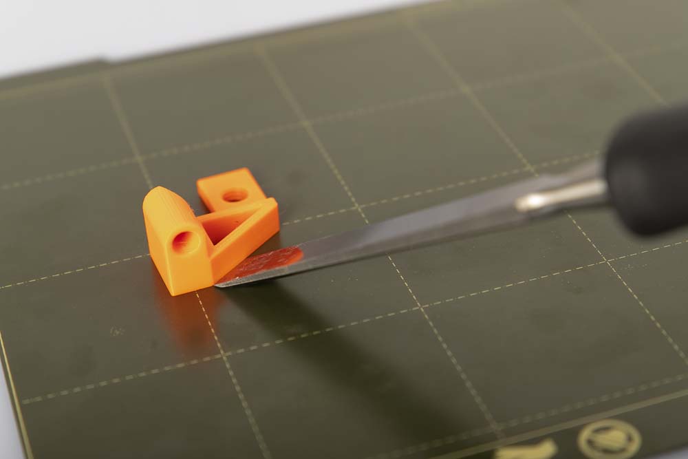 A chisel is used to remove a 3D printed part