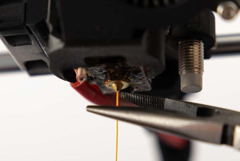 Mini needle-nose pliers attach to the nozzle and free the 3D printer from excess filament