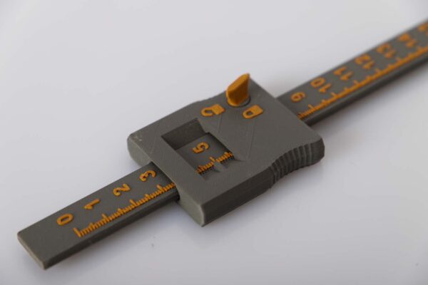 Details 3D printed depth gauge in dark gray and gold