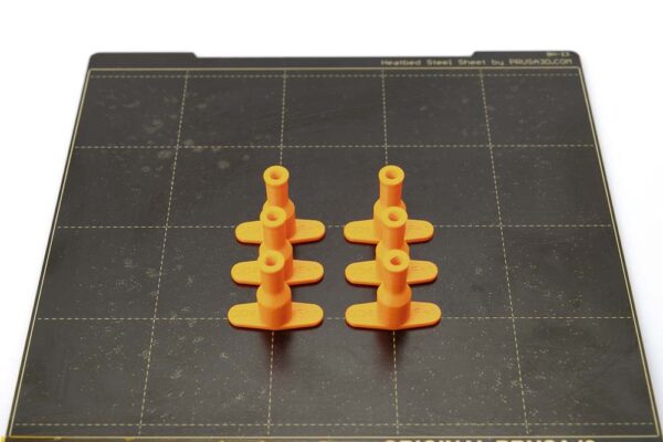Plate of the Prusa i3 MK3S on which 6 pieces of 3D printed tube plugs for variant A lie. All parts are printed in orange PETG filament with a layer height of 0.2 mm.