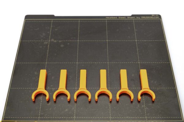 Print plate of the Prusa i3 MK3S on which 6 pieces of 3D printed tube plugs for variant B lie. All parts are printed in orange PETG filament with a layer height of 0.2 mm.