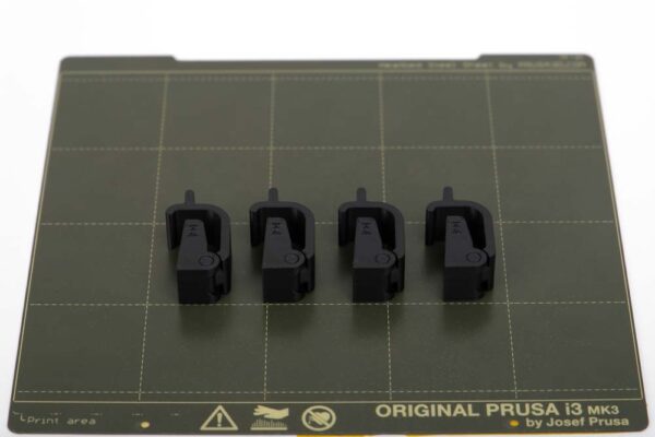 Printing plate of the Prusa i3 MK3S with 4 pieces of 3D printed closures for Samla boxes 22l in black PETG filament.