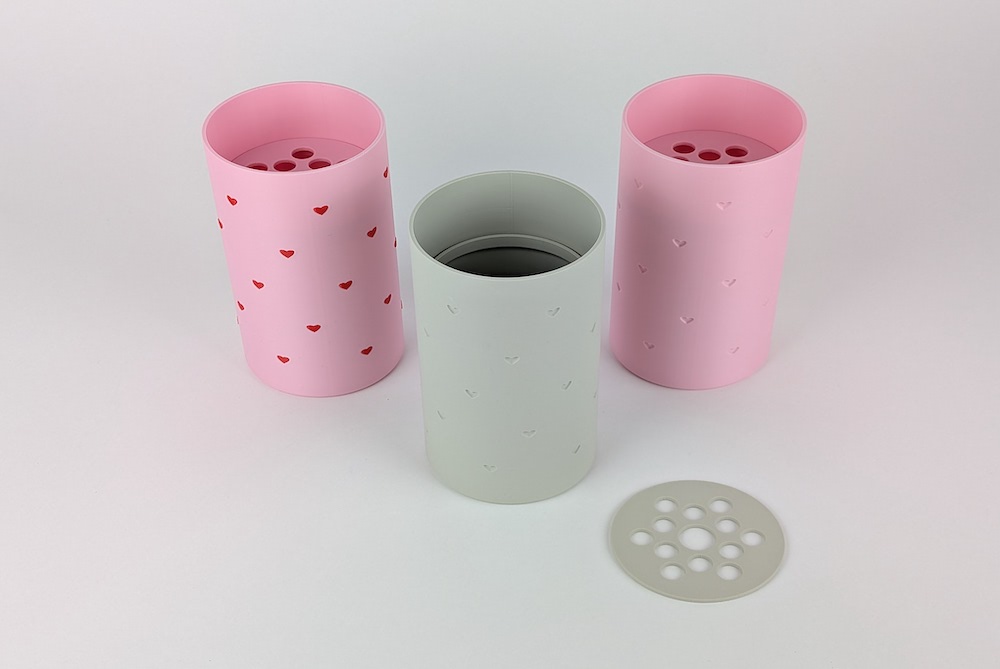 All versions of the heart-patterned flower vase, featuring embossed red hearts and recessed hearts designs in pink and beige.