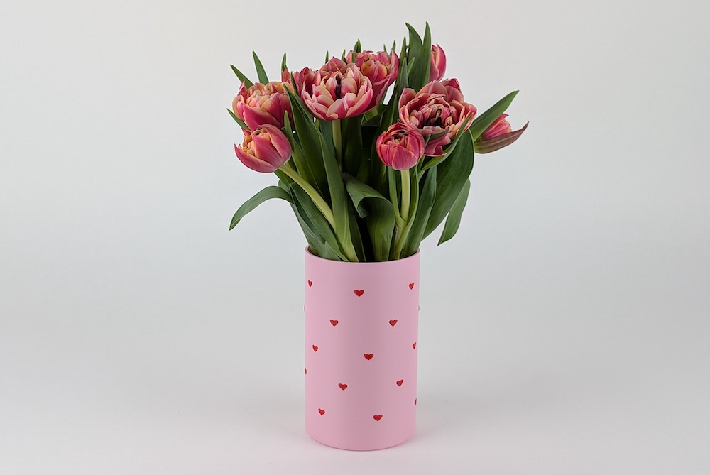 3D printed vase with flower disc insert, printed in pink filament, featuring a flower-themed design with embossed red hearts and floral details.