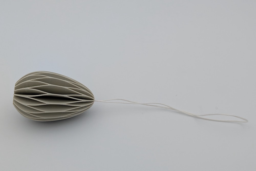 3D printed Easter egg with a threaded string in beige