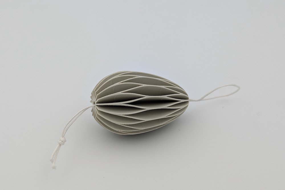 3D printed Easter egg with a string and knot at the end in beige