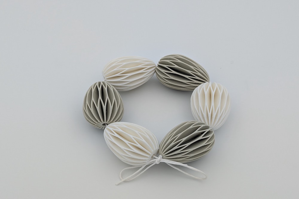 Wreath made of small printed Easter eggs in beige and white