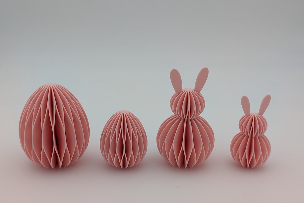 3D printable pink honeycomb Easter decoration set, featuring two bunnies and two eggs in various sizes.
